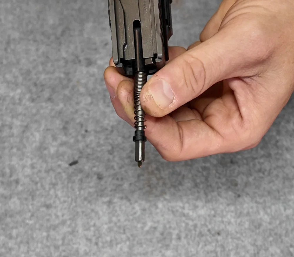 Jak wymienić sprężyny w Glocku Gen 1–3? Poradnik na przykładzie Glocka Gen 3 11 Ściśnięta sprężyna iglicy odsłania połówki opory